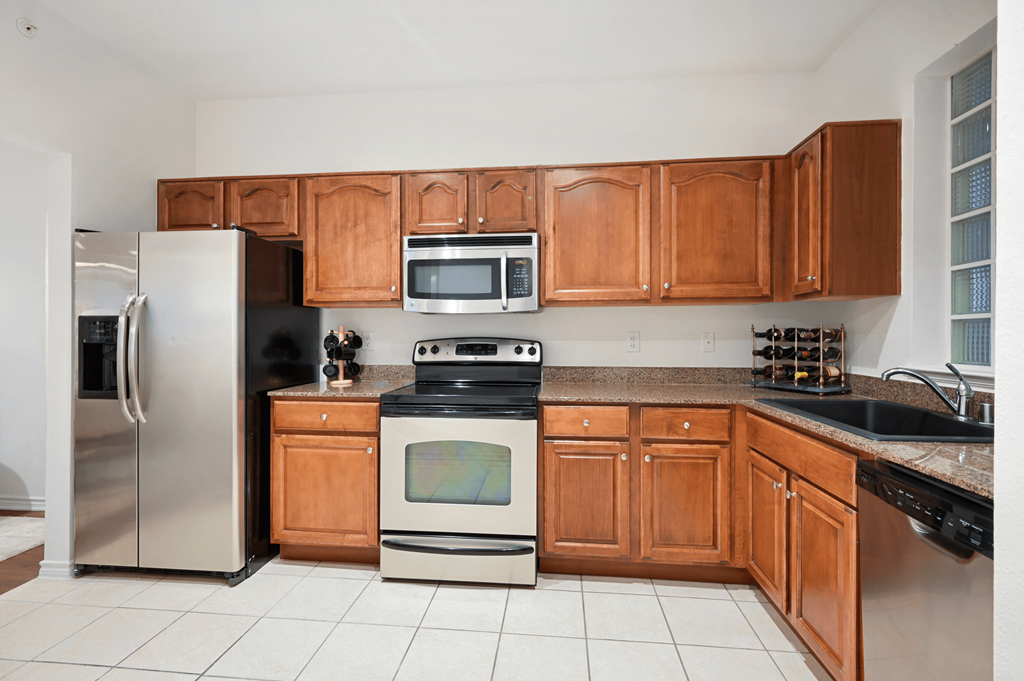 a kitchen with wooden cabinets and stainless steel appliances