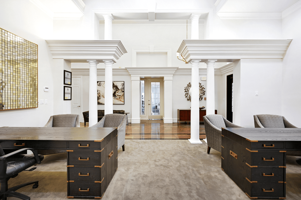 a conference room with two desks and chairs and a rug