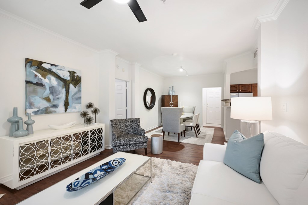 a living room with a white couch and a dining room table