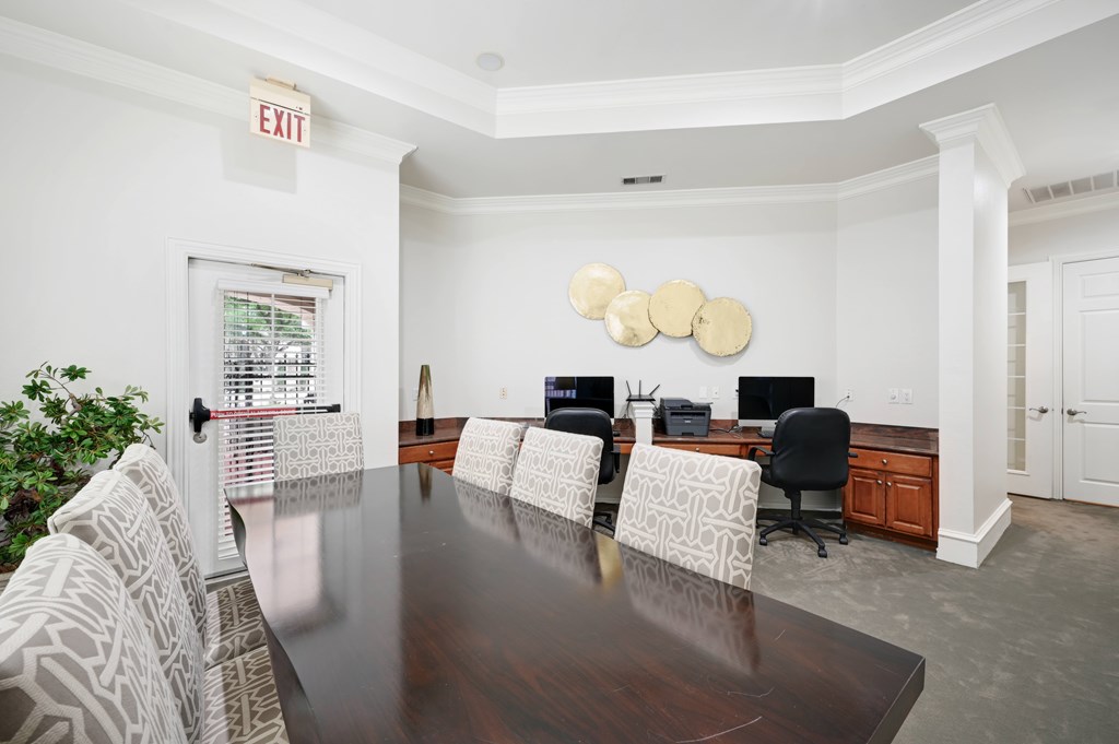 a conference room with white walls and a wooden table and chairs