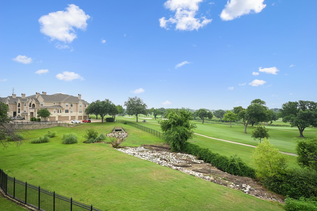 a view of a golf course with a house in the background