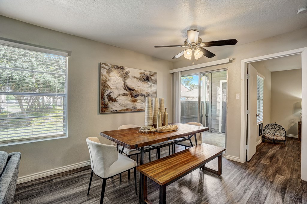 a dining room with a table and chairs and a ceiling fan