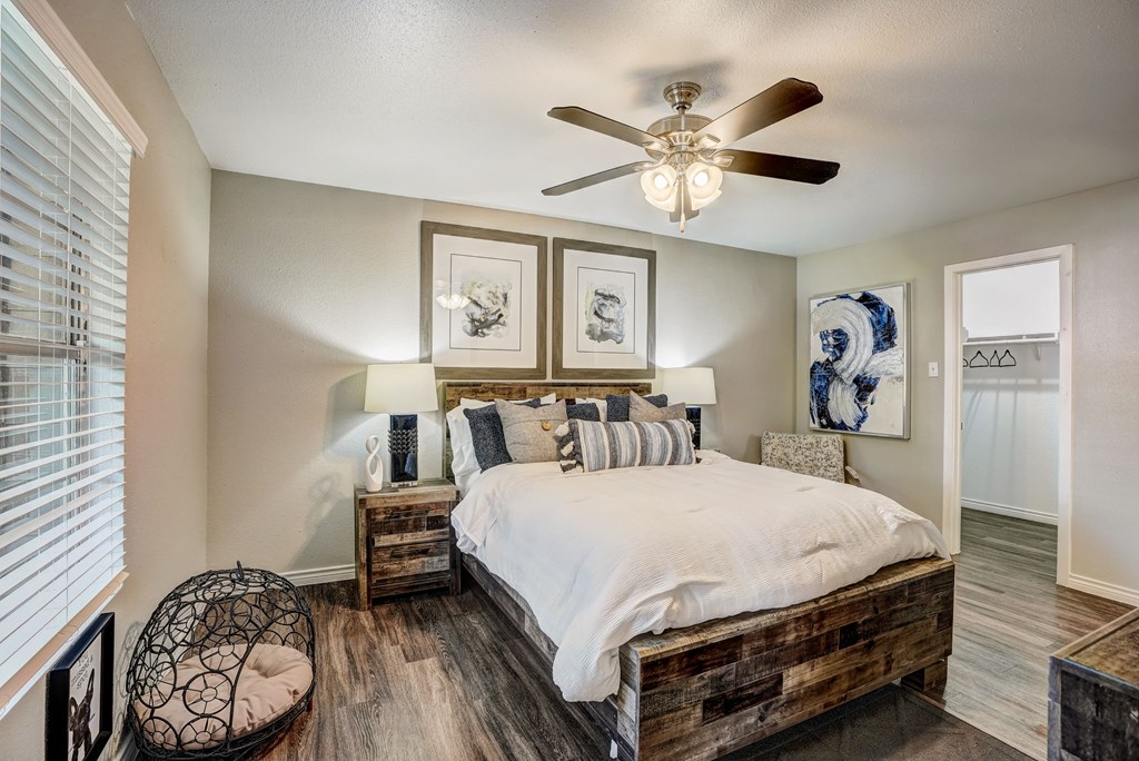the master bedroom has a comfy bed and a ceiling fan