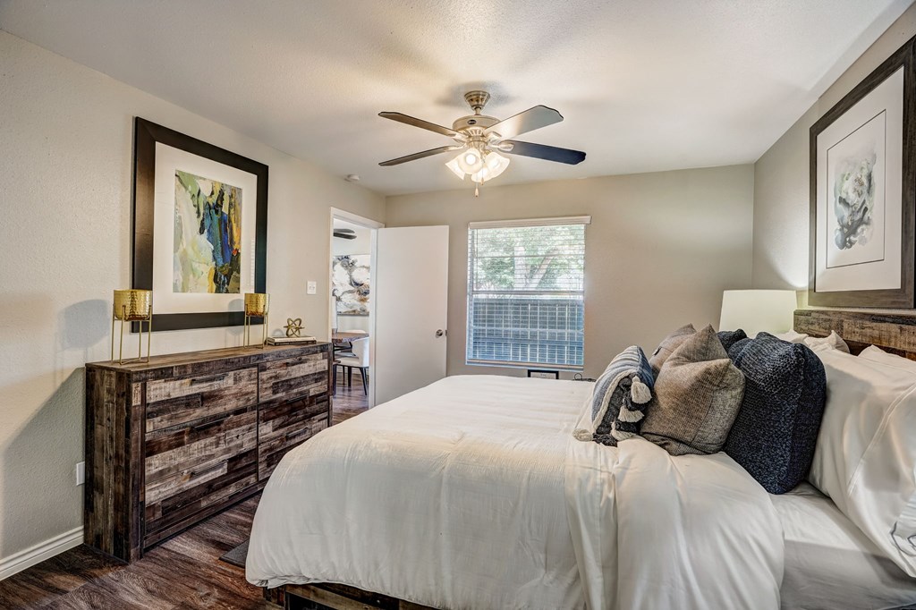 a bedroom with a large bed and a ceiling fan