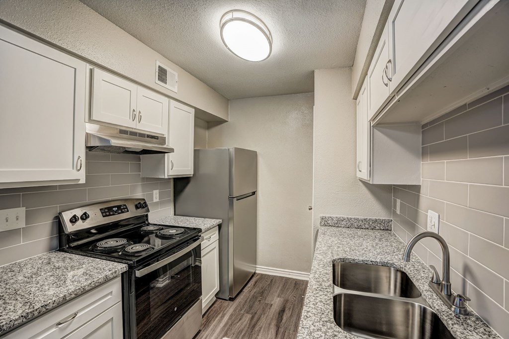 a kitchen with granite counter tops and stainless steel appliances