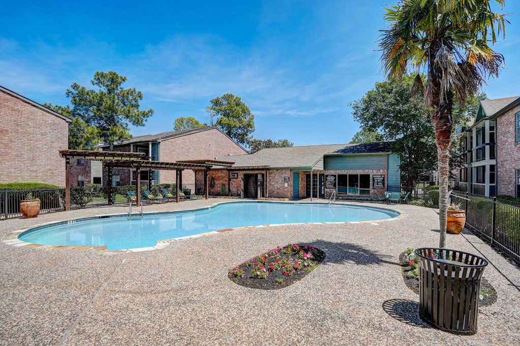 a large swimming pool in front of a house with a palm tree