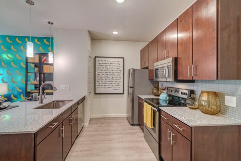 A kitchen with brown cabinets and a fridge.