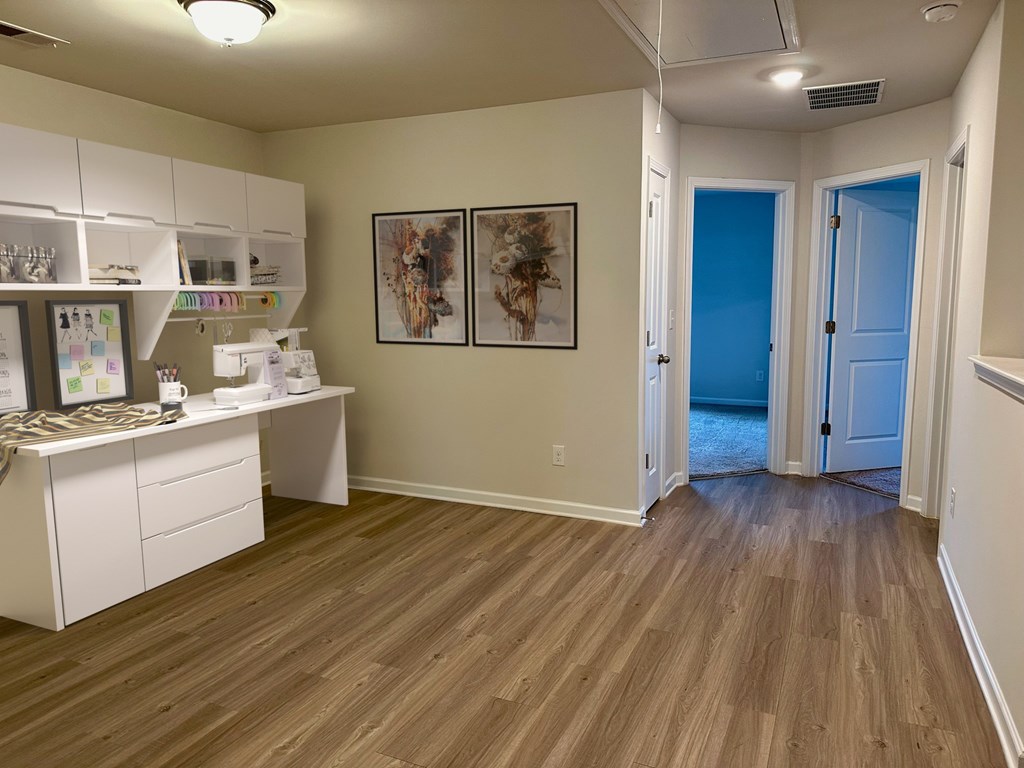 a kitchen and living room with wood floors and white cabinets