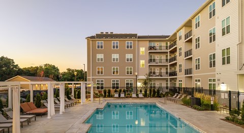 A large apartment complex with a pool in the foreground.