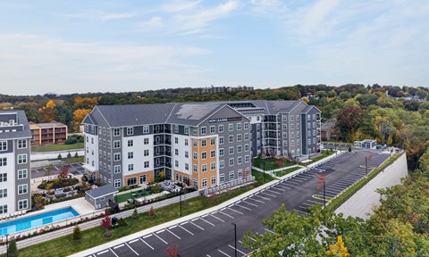 A large apartment complex with a pool and a parking lot.