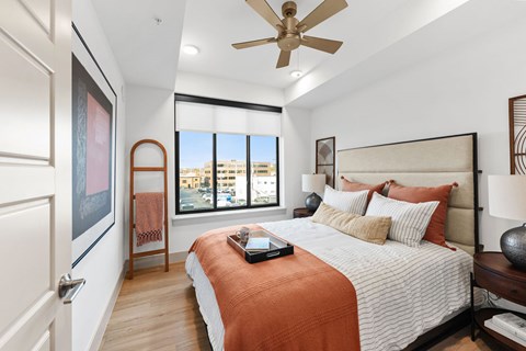 A bedroom with a large bed and a ceiling fan.