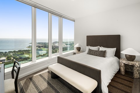 A bedroom with a large bed and a view of the ocean.