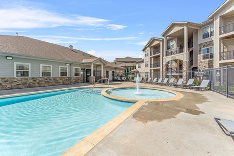 A swimming pool with a fountain in the middle of it.