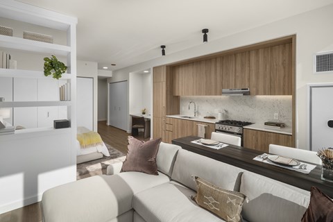A modern living room with a white couch and a kitchen area in the background.