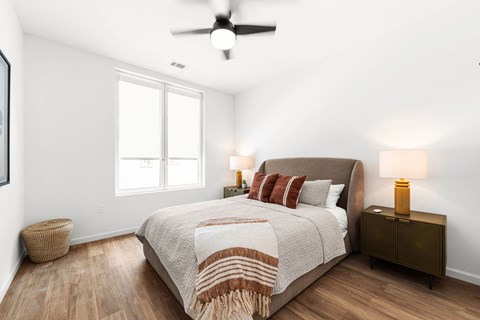 A bedroom with a large bed and a ceiling fan.