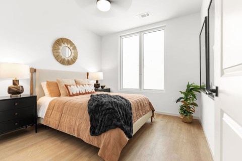 A bedroom with a bed, a dresser, and a mirror on the wall.
