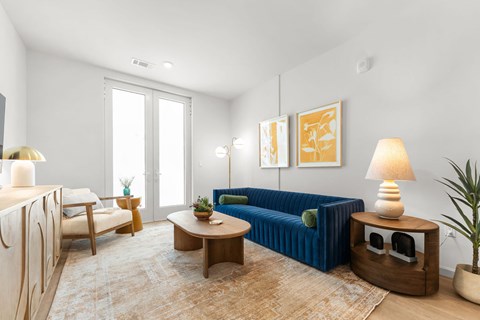 A living room with a blue couch and a wooden coffee table.