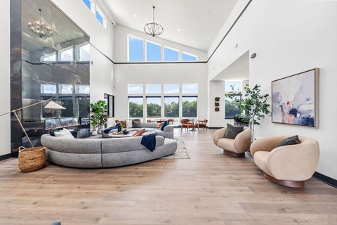 A modern living room with a large grey sofa and a wooden floor.