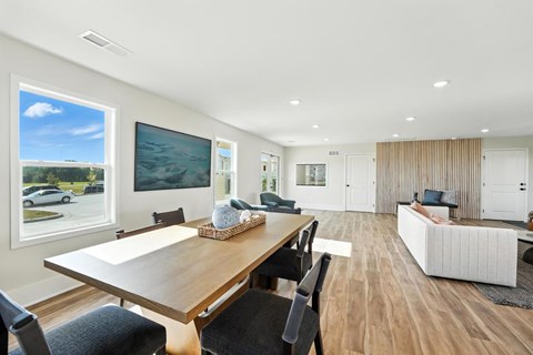 A modern dining room with a wooden table and chairs.