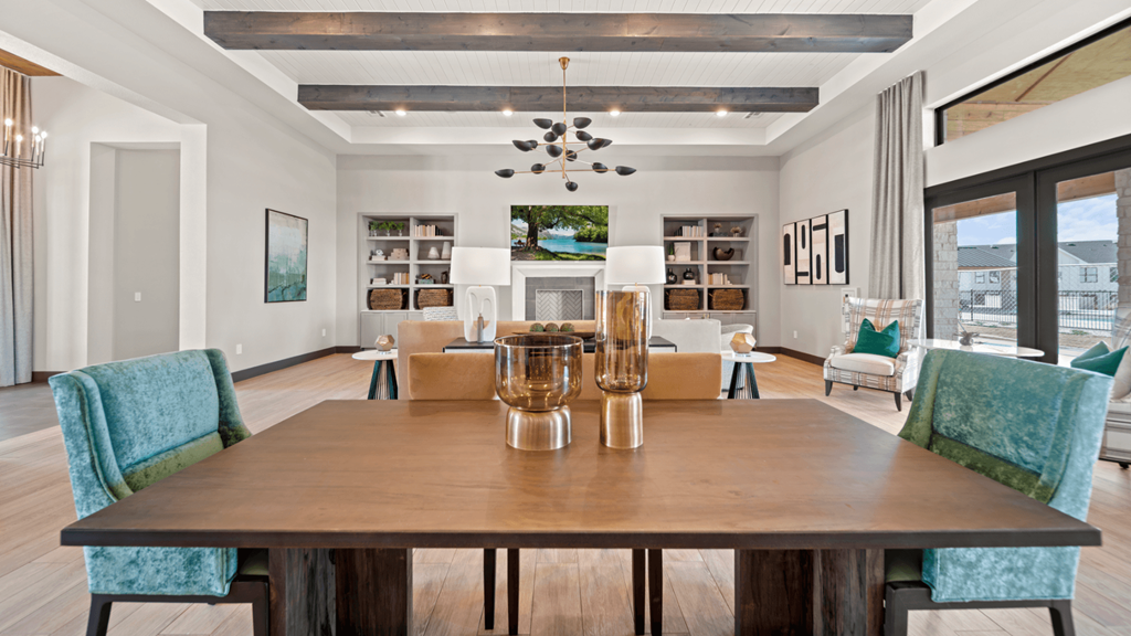 a dining room table with blue chairs and a living room with a fireplace