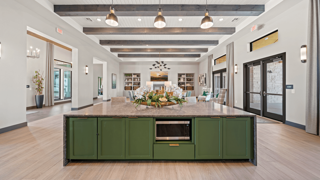 a large kitchen with green cabinets and a center island