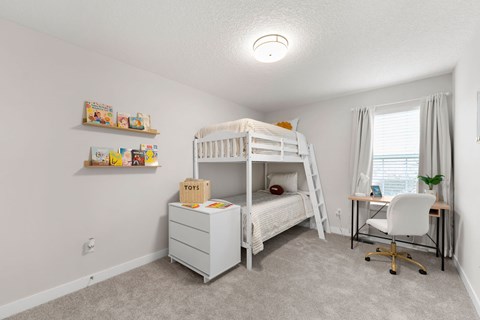 A white bunk bed with a desk and chair in a room.