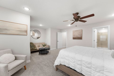 A bedroom with a large bed and a ceiling fan.