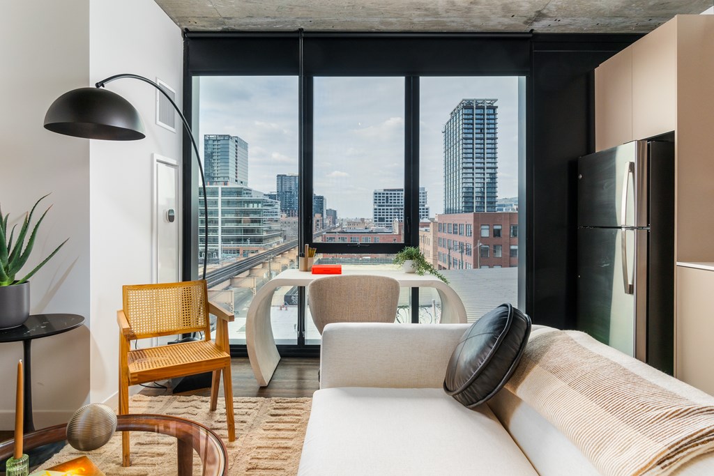 a living room with a view of a city and a white couch and a table
