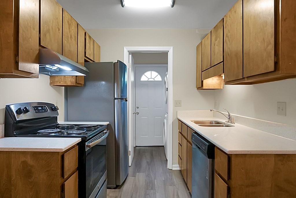 A kitchen with wooden cabinets and a white counter top.