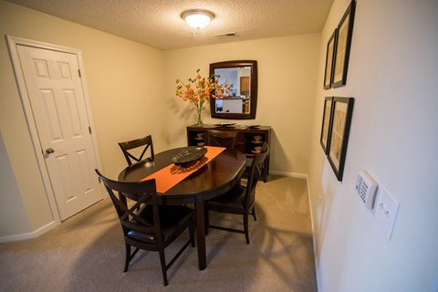 A dining room with a table and chairs.