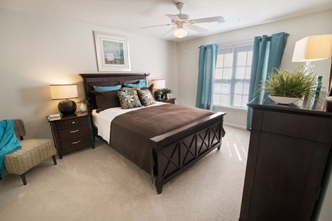 A bedroom with a large bed and a ceiling fan.
