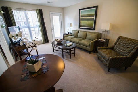 A living room with a green sofa and a brown table.