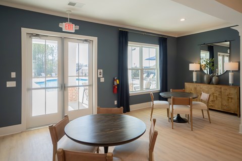 Clubhouse living room with additional table seating, looking onto the pool deck.