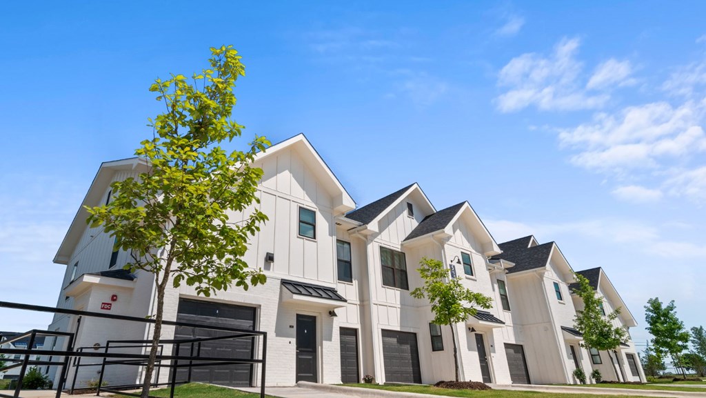 a row of town houses with a tree in front of them