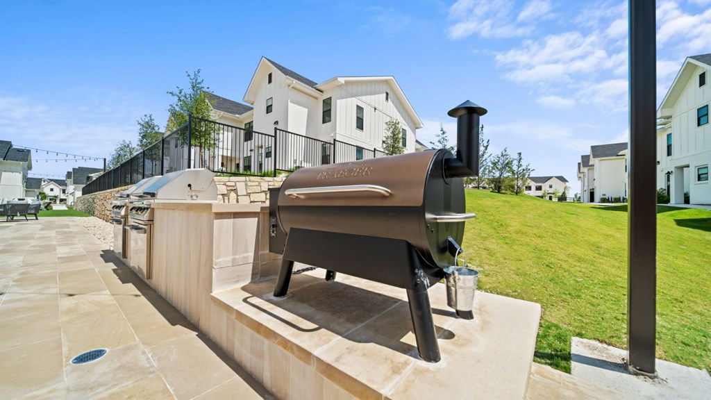 a barbecue grill on a patio in front of a house