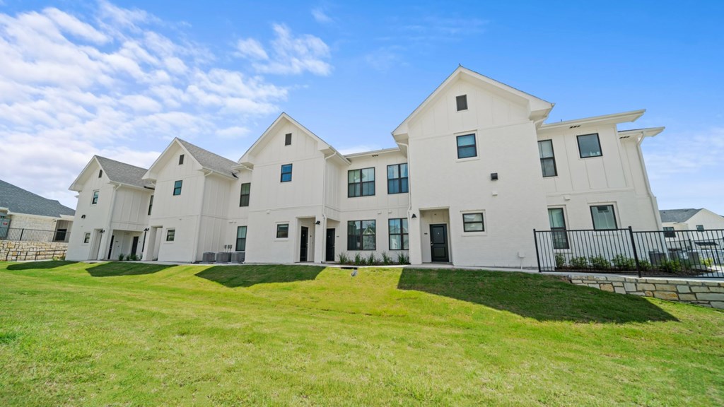 a group of white houses with grass in front of them