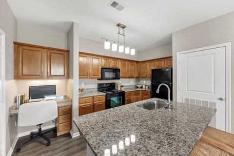 A kitchen with granite countertops and wooden cabinets.