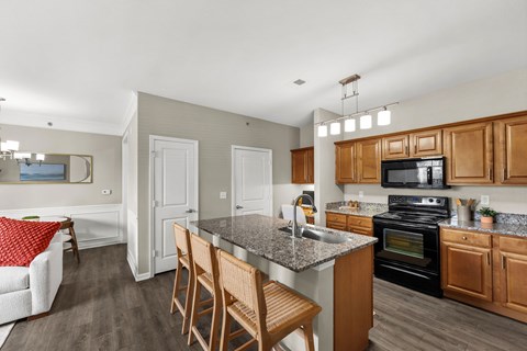 A kitchen with a black oven and wooden cabinets.