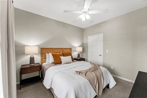 A bedroom with two beds and a ceiling fan.