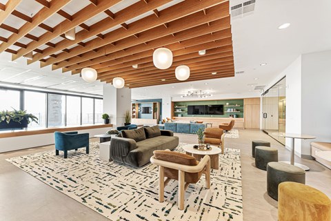 A spacious living room with a patterned rug and wooden furniture.