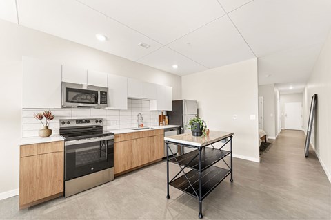 A kitchen with a black table and a stove with a pot on it.