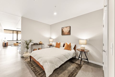 A bedroom with a large bed and a painting on the wall.