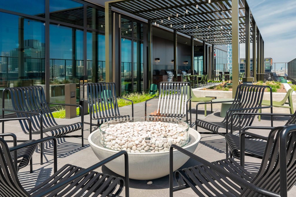 a patio with chairs and a fire pit