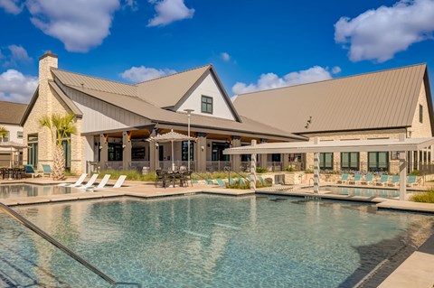 A large house with a pool in front.