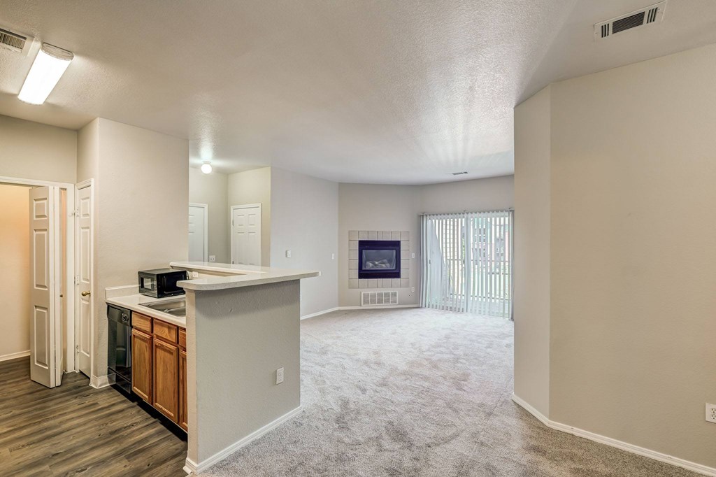 an empty living room and kitchen with a large window