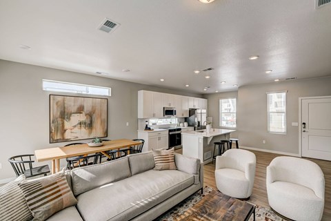 A modern living room with a grey sofa and a wooden dining table.