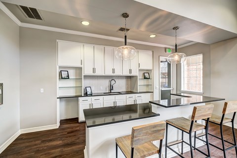 a kitchen with white cabinets and a black counter top