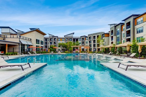 a swimming pool with an apartment building in the background