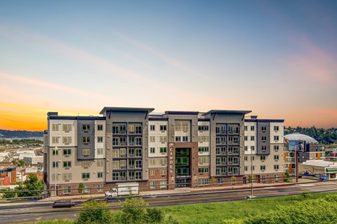 A modern apartment building with a green lawn in front.