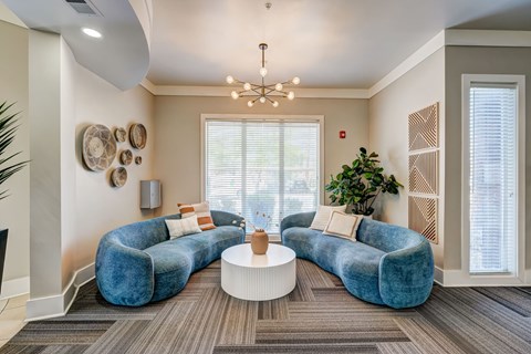 A living room with a blue couch and a white coffee table.